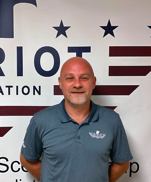 patriot remediation technician in front of logo